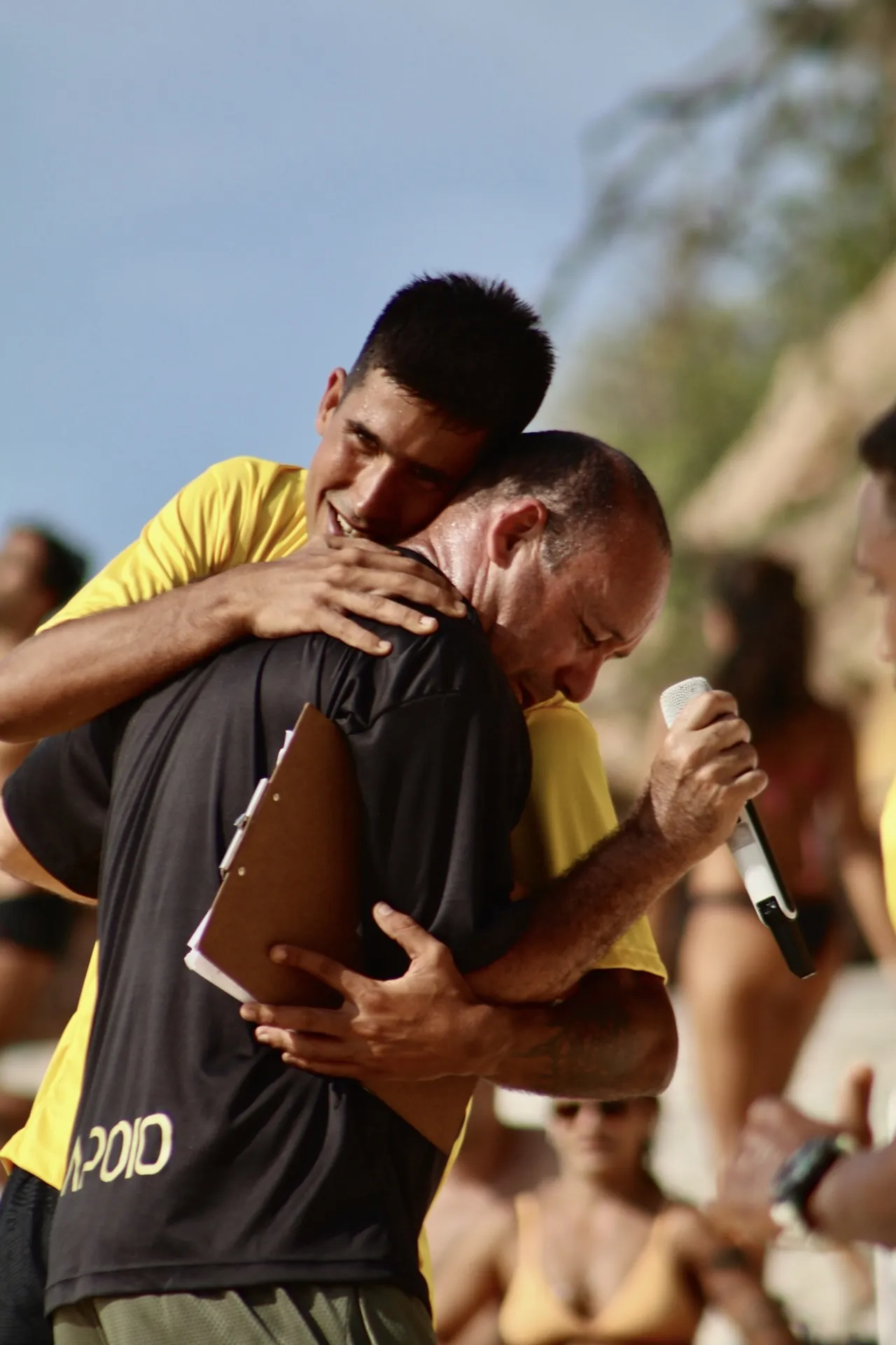Abraço de comemoração entre jogadores na areia
