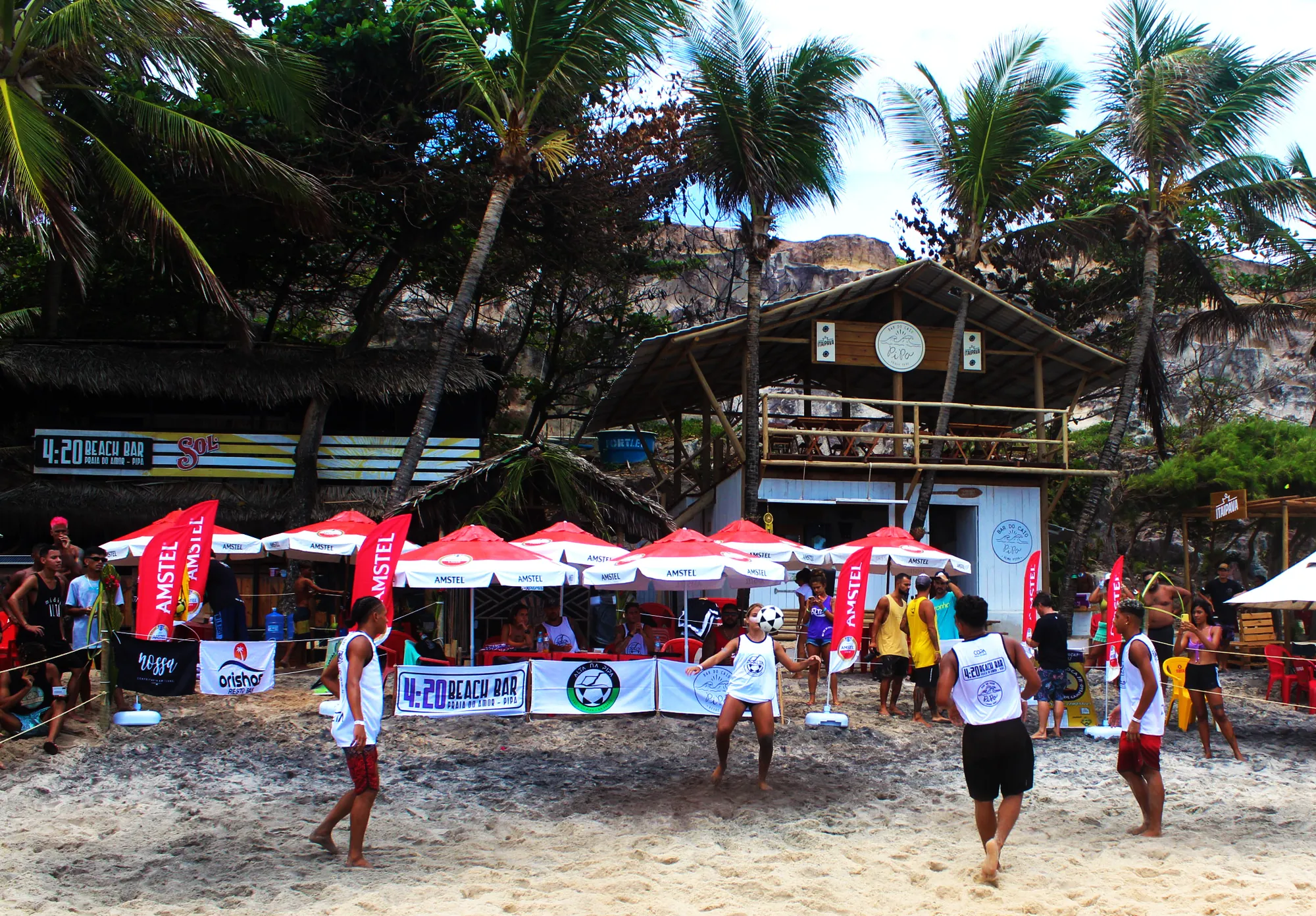Arena de altinha montada na areia de Pipa, com tendas e bandeiras de evento